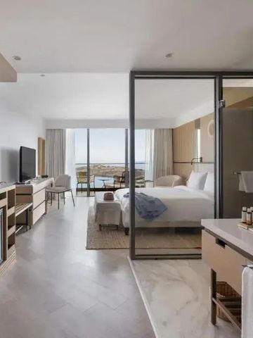 Helles, modernes Hotelzimmer mit großem Fenster und Meerblick