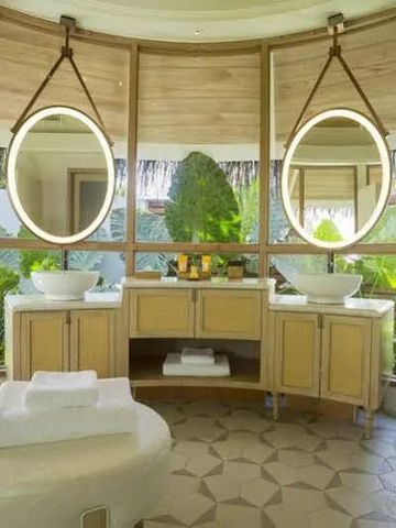 Modernes Badezimmer mit zwei Waschbecken und großen Fenstern mit Gartenblick