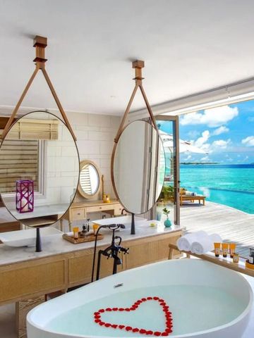 Luxuriöses Badezimmer mit freistehender Badewanne und Blick auf das Meer