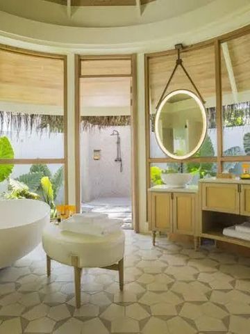 Geräumiges Badezimmer mit Badewanne und Zugang zu einer Outdoor-Dusche