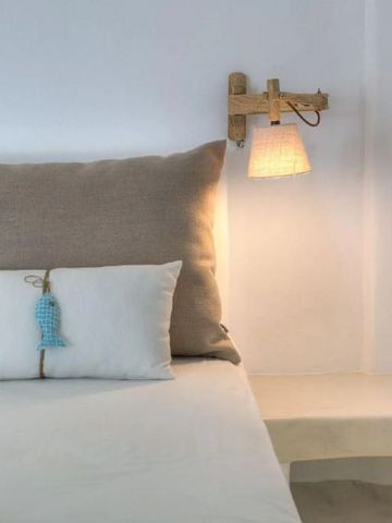 Helles Zimmer mit dekorativem Kopfkissen und stilvoller Lampe