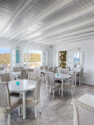 Heller Restaurantbereich mit weißer Einrichtung und Meerblick