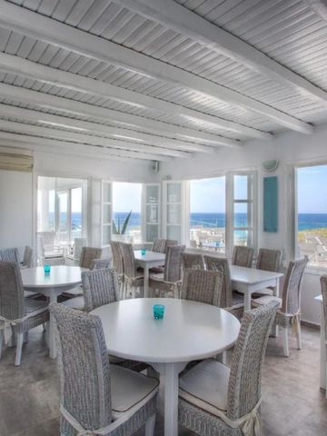 Lichtdurchfluteter Speisesaal mit Meerblick und weißen Holzmöbeln