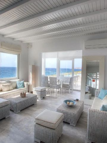 Helle Lounge mit Rattanmöbeln und Panoramablick auf das Meer