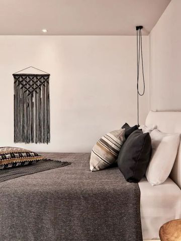 Geräumiges Zimmer mit modernem Dekor und Bett im Minos Beach Art Hotel