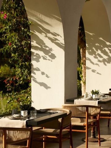Elegante Restaurantterrasse im Freien mit bogenförmigen Säulen und Pflanzen