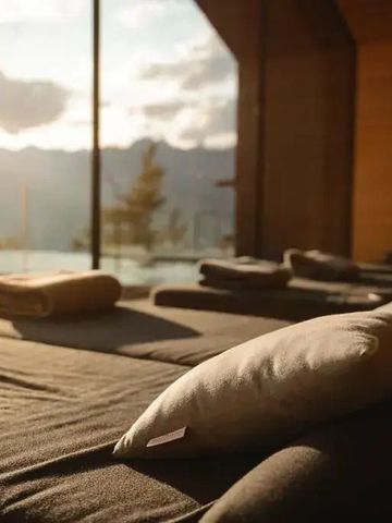 Wellnessbereich mit Liegen und Blick auf die Berge im Sonnenuntergang