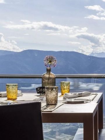 Gedeckter Tisch mit Glasgeländer und Bergblick