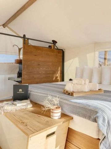 Komfortables Bett in einem Zeltzimmer mit moderner Einrichtung