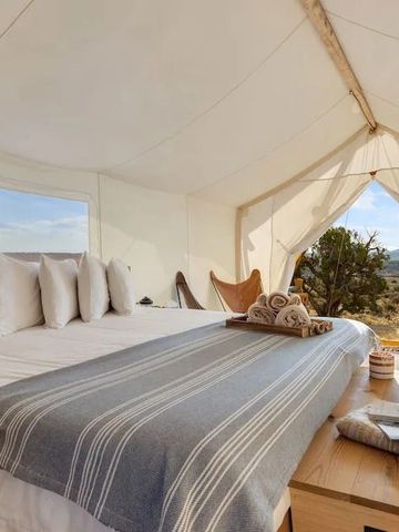 Hell dekoriertes Zeltzimmer mit Aussicht auf die Natur