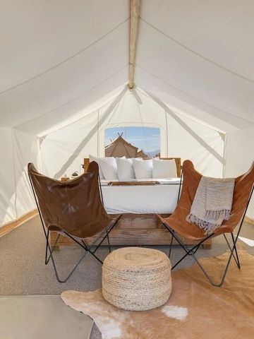 Innenansicht eines luxuriösen Zeltes mit Sesseln und Couch