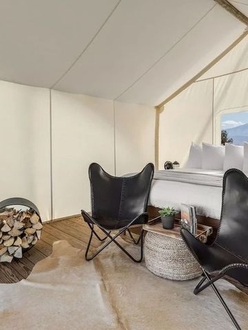 Großzügiges Zeltinterieur mit Ledersesseln und stilvoller Einrichtung