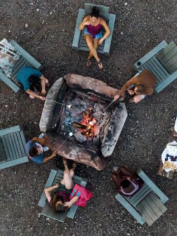 Vogelperspektive auf Lagerfeuer und umgebende Stühle