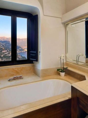 Luxuriöses Badezimmer mit großer Badewanne und Blick auf Küstenlandschaft