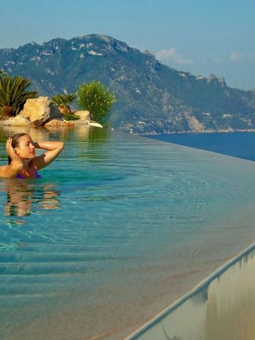 Frau im Infinity Pool mit Bergblick