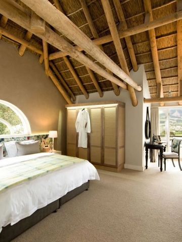 Luxuriöses Zimmer mit rustikalen Holzbalken, großen Fenstern und Bergblick