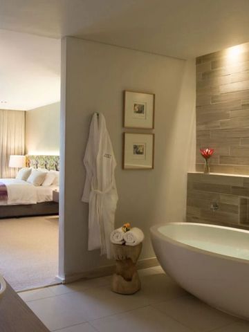 Luxuriöses Bad mit freistehender Wanne und Blick ins Schlafzimmer im Hotelmont Rochelle