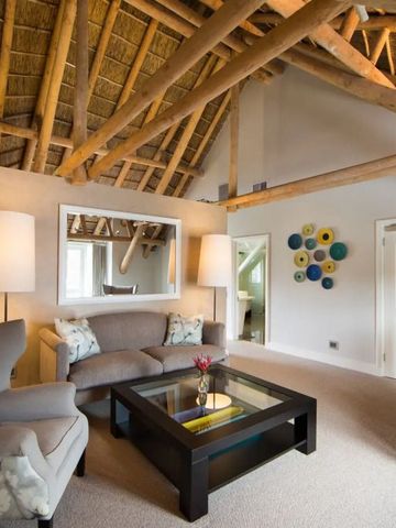 Heller Wohnbereich mit offenem Dachstuhl und moderner Einrichtung im Hotelmont Rochelle