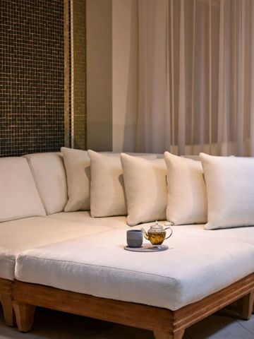 Gemütlicher Lounge-Bereich mit weißen Kissen auf hellem Sofa