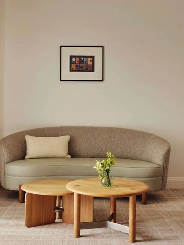 Elegante Lounge mit runden Tischen und einem Sofa in neutralen Tönen