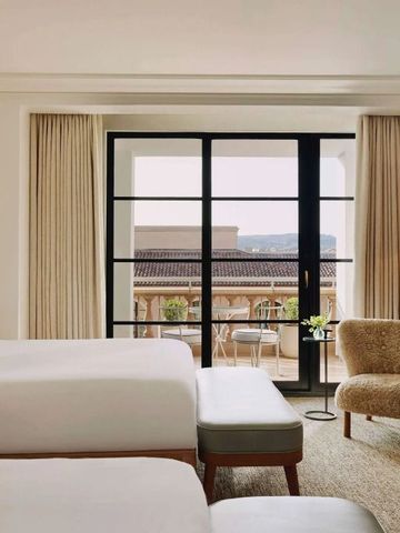 Zimmer mit Betten und Zugang zum Balkon mit Ausblick