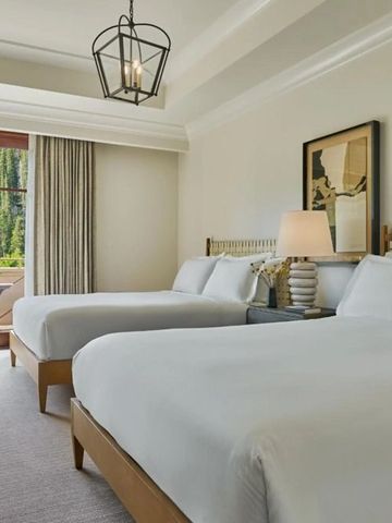 Doppelzimmer mit zwei Betten und Balkon mit Waldblick.