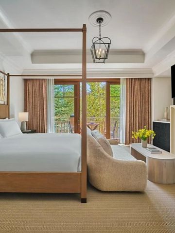 Elegantes Schlafzimmer mit Himmelbett, Kamin und Balkon.