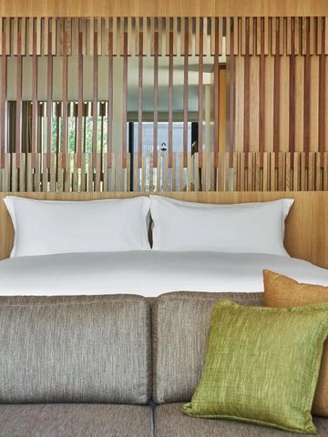 Helles Hotelzimmer mit großen, gemütlichen Betten und modernen Holzakzenten.