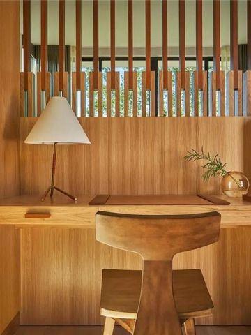 Holzschreibtisch mit Lampe und stilvoller Dekoration in modernem Hotelzimmer