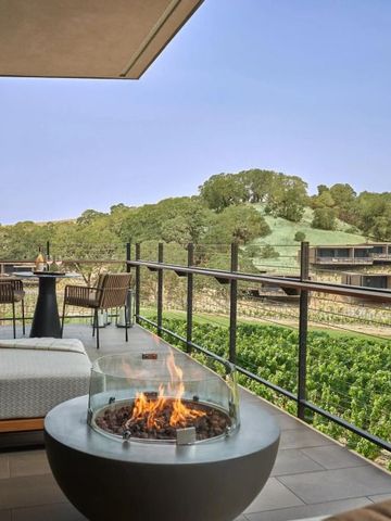 Hotelbalkon mit Sitzecke und Feuerstelle, Blick auf grüne Landschaft