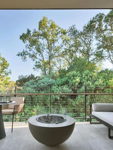 Private Terrasse mit Sitzgelegenheit und Blick auf grüne Bäume.