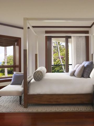 Geräumiges Hotelzimmer mit Himmelbett und Meerblick in moderner Einrichtung.