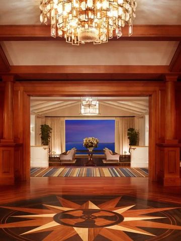 Luxuriöse Lobby mit Holzdekor und spektakulärem Meerblick durch große Fenster.