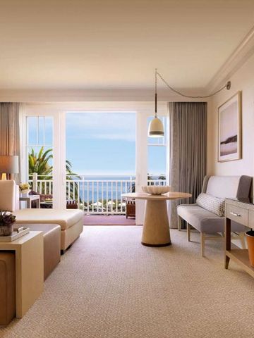 Geräumiges Wohnzimmer in einer Suite mit Blick auf den Ozean und modernem Dekor.