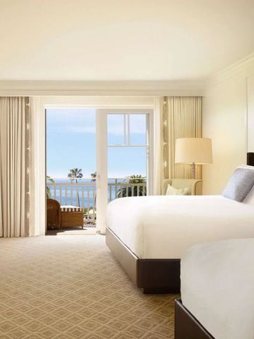 Helles Zimmer mit zwei Betten und Balkon mit Meerblick