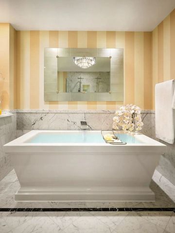 Helles Badezimmer mit großer Badewanne und Marmordekor