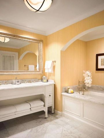 Elegantes Badezimmer mit Marmorbadewanne und großem Spiegel