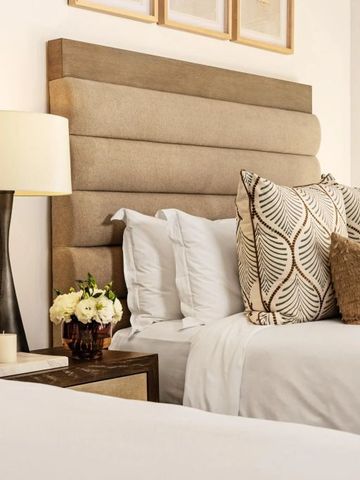 Detail einer eleganten Suite mit gemütlichem Bett und dekorativen Kissen