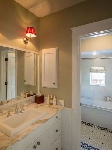 Luxuriöses Badezimmer mit Marmoroberflächen und großzügiger Badewanne