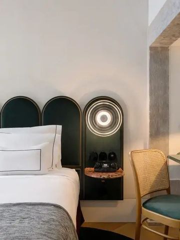 Hotelzimmer mit gemütlichem Bett und stimmungsvollem Beleuchtungselement an der Wand