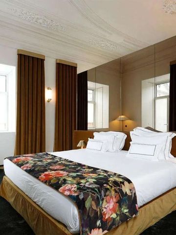 Luxuriöses Schlafzimmer mit dekorativer Decke und floralem Design im Montebelo Vista Alegre Hotel