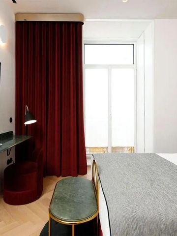 Modernes Hotelzimmer mit Doppelbett, roten Vorhängen und eingebautem TV