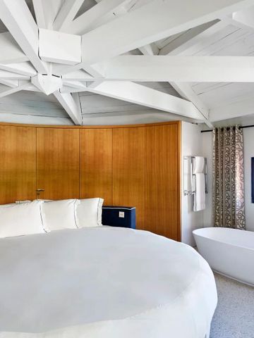 Geräumiges Hotelzimmer mit freistehender Badewanne und Meerblick.