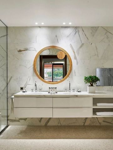 Modernes Badezimmer mit Marmor und rundem Spiegel