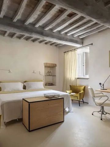 Helles Doppelzimmer mit freiliegenden Holzbalken und modernem Design.