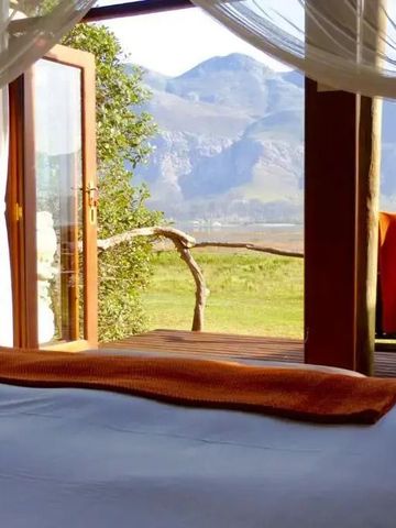 Schlafzimmer mit Blick auf die Berge durch große Glastüren