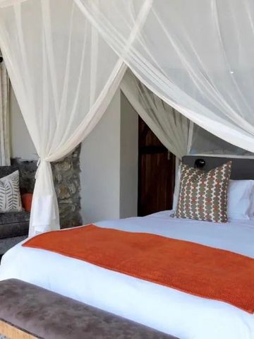 Gemütliches Schlafzimmer mit orangen Akzenten und Steinwänden