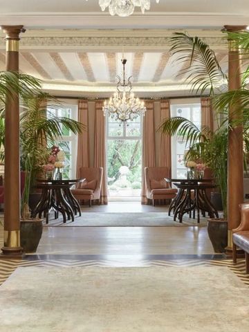 Elegante Hotel-Lobby mit Palme, Säulen und Kronleuchter