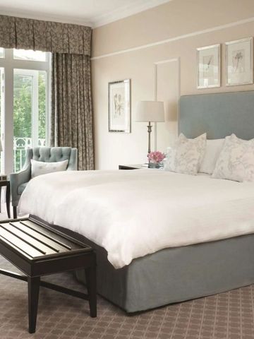 Luxuriöses Schlafzimmer mit großem Fenster und eleganten Möbeln