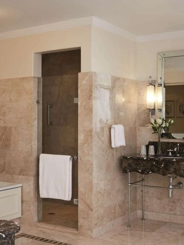 Elegantes Badezimmer mit Marmorfliesen und großer Dusche